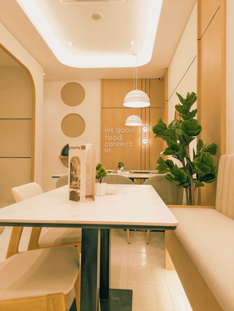 Bright cafe interior with arched alcoves, pale walls and a stone counter.